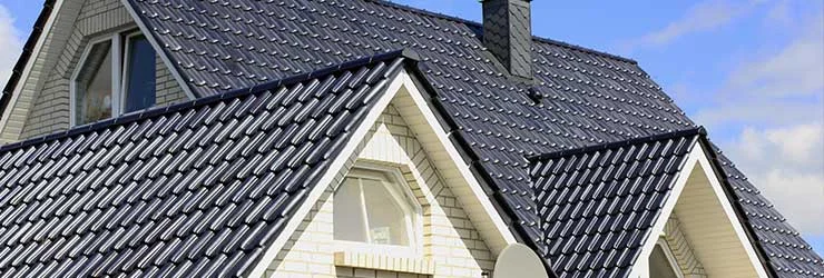 Strak pannendak met glanzende donkerblauwe dakpannen.