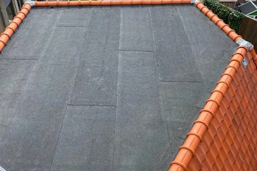 Rode Franse kap met een plat dak van bitumen in de nok.