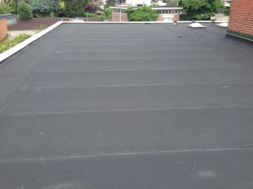 Middelgroot bitumen dak met gelijkmatige banen en enkele lichtkoepels.